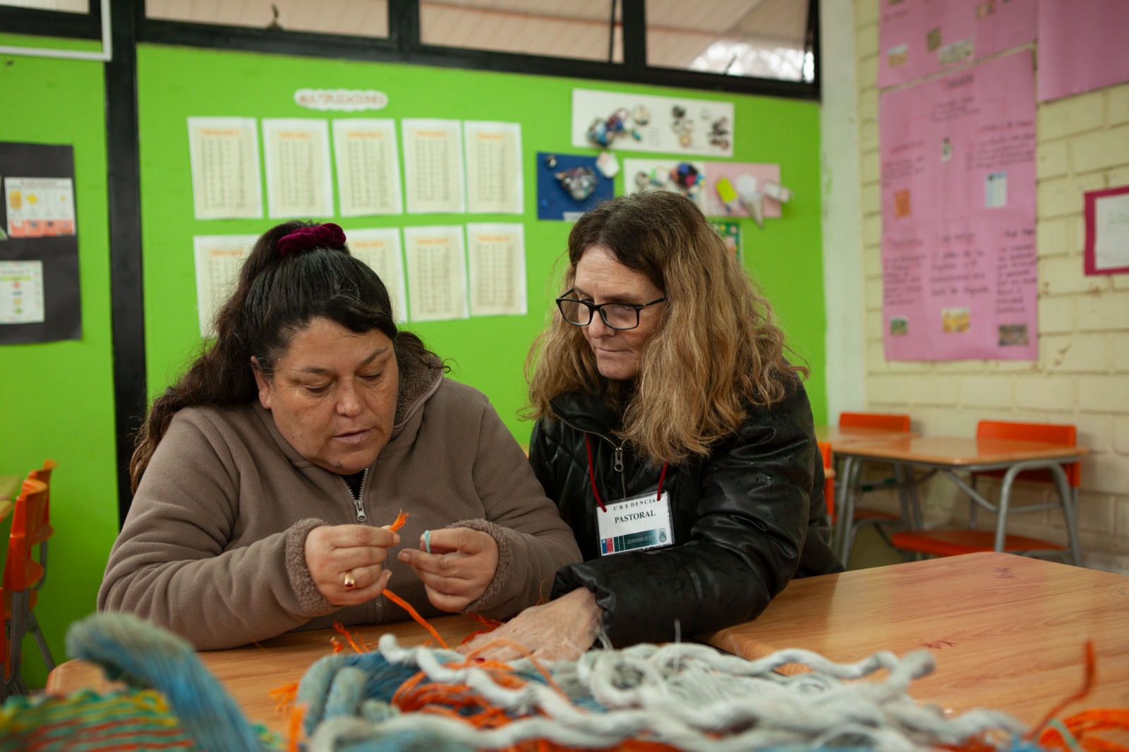 Voluntaria acompañando a una mujer en un taller de tejido